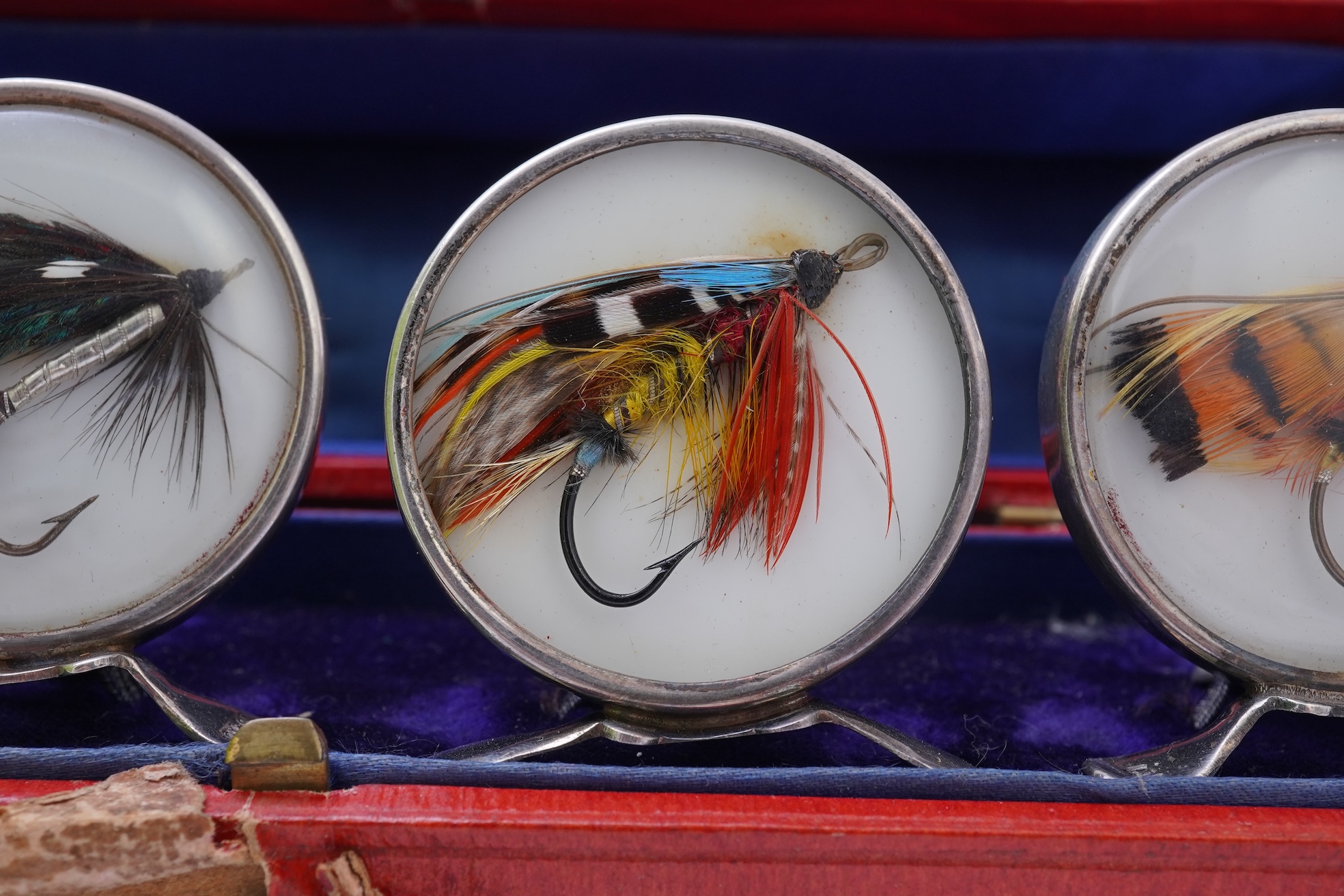 A set of four early 20th century silver mounted fishing related novelty menu holders, by Grey & Co, housed in a red leather case with gilt initials RV